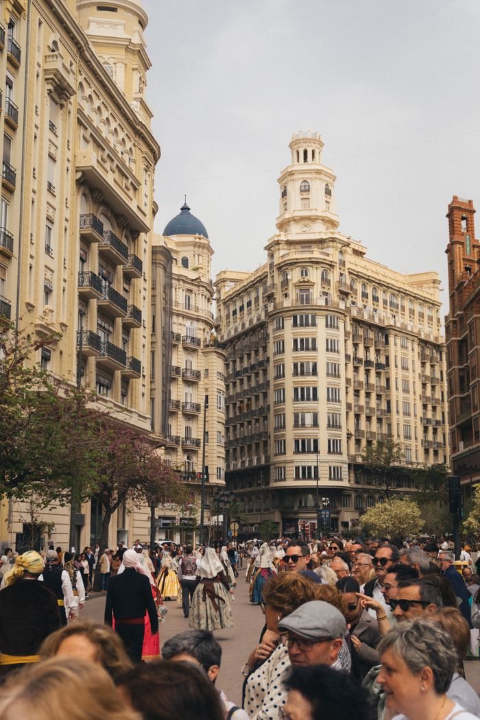 Home Crowds gather in Valencia's historic city center, surrounded by iconic architecture and vibrant street life.